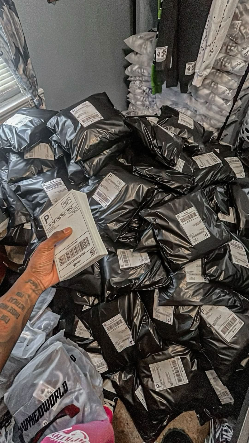 A stack of black USPS Priority Mail packages — orders going out